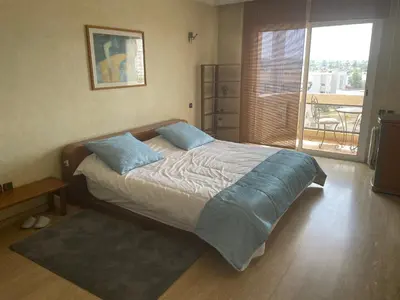 a bedroom with a large bed with blue pillows at Residence Elite appartement de luxe in Casablanca