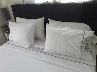 a white bed with four white pillows on it at Dior D'Anfa in Casablanca