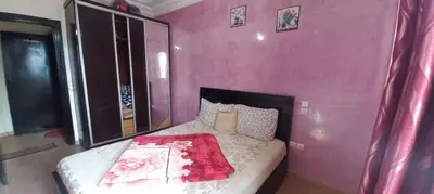 a bedroom with a bed with a pink wall at Mohammed V International Airport HOUSE in Nouaseur