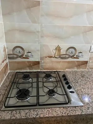 a stove top in a kitchen with plates and a tea kettle at Mohammed V International Airport HOUSE in Nouaseur