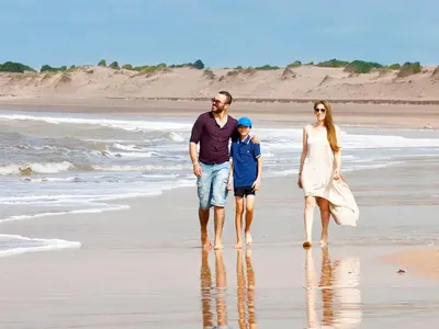 a family walking on the beach at Magnifique Appart a Savannah Beach in Sidi Rahal