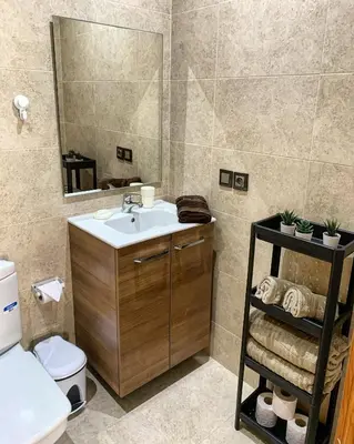 a bathroom with a sink and a toilet and a mirror at Magnifique Appart a Savannah Beach in Sidi Rahal