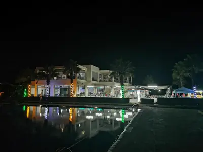 a building at night with a pool in front of it at Magnifique Appart a Savannah Beach in Sidi Rahal