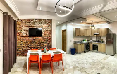 a kitchen with a table and chairs in a room at Magnifique Appart a Savannah Beach in Sidi Rahal
