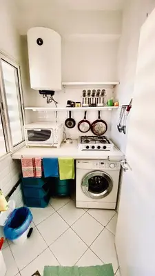 a small kitchen with a stove and a washing machine at Modern & Sunny new appartement 2 rooms in Rabat centre - Hay Riad in Rabat
