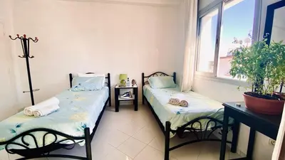 two twin beds in a room with a window at Modern & Sunny new appartement 2 rooms in Rabat centre - Hay Riad in Rabat