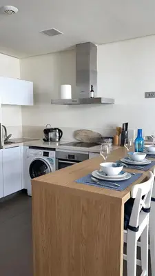 a kitchen with a table with plates and wine glasses on it at Luxury Anfaplace Living Resort in Casablanca