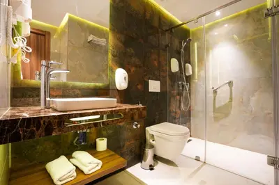 a bathroom with a shower and a sink and a toilet at First Suites Hôtel in Rabat