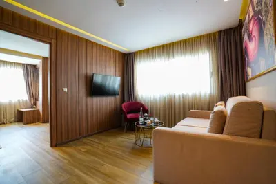 a living room with a couch and a television at First Suites Hôtel in Rabat