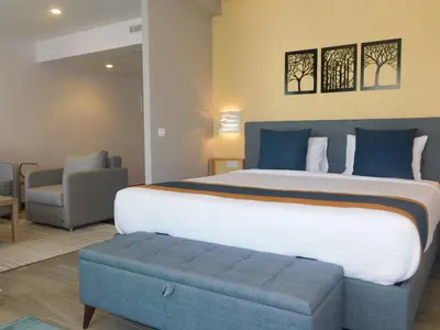 a bedroom with a large bed and a chair at Gardenia Boutique Hotel in Rabat