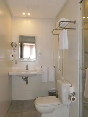 a white bathroom with a toilet and a sink at Gardenia Boutique Hotel in Rabat