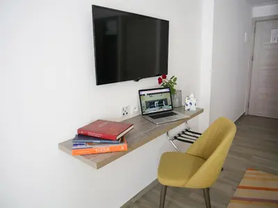 a room with a desk with a laptop and a chair at Gardenia Boutique Hotel in Rabat