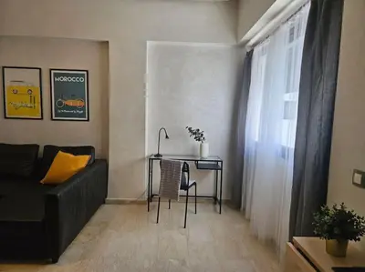 a living room with a table and a couch at Très bel appartement en face du parc, près du Novotel in Mohammedia