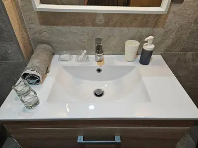 a white sink in a bathroom with a mirror at Très bel appartement en face du parc, près du Novotel in Mohammedia