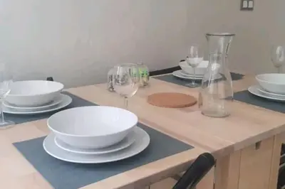 a table with plates and wine glasses on it at Très bel appartement en face du parc, près du Novotel in Mohammedia