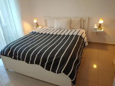 a bed with a black and white striped comforter in a room at Atlantic studio in Atlantic Plaza with Free parking , Available public bus to,from casa port station and downtown in Casablanca