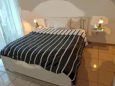 a bed with a black and white striped comforter in a room at Atlantic studio in Atlantic Plaza with Free parking , Available public bus to,from casa port station and downtown in Casablanca