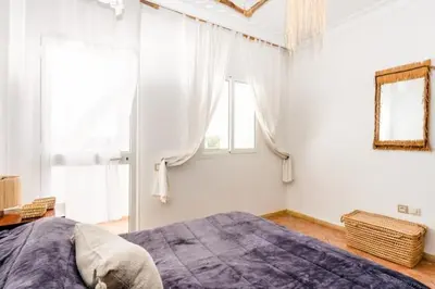 a bedroom with a large bed and two windows at Sea view Tamaris Dar Bouazza in Tamaris