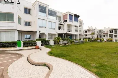 a walkway in front of a large apartment building at Sea view Tamaris Dar Bouazza in Tamaris