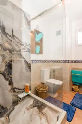 a bathroom with a toilet and a glass wall at Sea view Tamaris Dar Bouazza in Tamaris