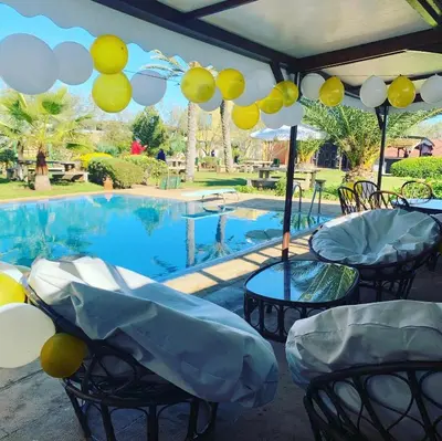 a pool with chairs and balloons in front of it at Equi Palace & SPA Near Aeroport in Berrechid