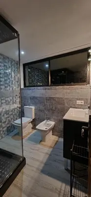 a bathroom with two sinks and a toilet and a mirror at Equi Palace & SPA Near Aeroport in Berrechid