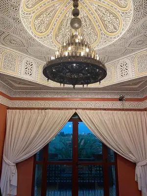 a chandelier hanging from a ceiling with a window at Equi Palace & SPA Near Aeroport in Berrechid