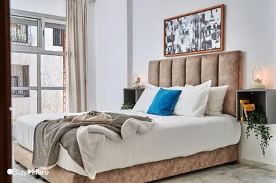 a bedroom with a large bed with white and blue pillows at Stayhere Rabat - Agdal 2 - Classic Residence in Rabat