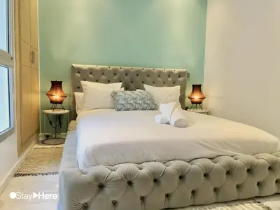 a bedroom with a large bed with two lamps at Stayhere Rabat - Agdal 2 - Classic Residence in Rabat