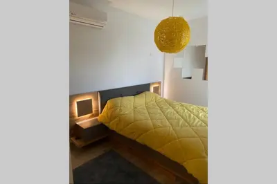 a bedroom with a bed with a yellow blanket at Appt BOUZNIKA EDEN ISLAND pied sur Mer pour FAMILLE et Couple MARIE in Bouznika
