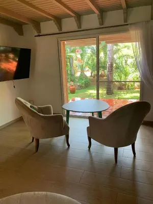 a living room with two chairs and a table and a window at Palmeraie skhirat 2 in Skhirat