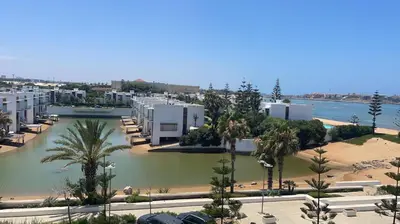 a view of a city with palm trees and buildings at Eden Island Apartment with a View in Sidi el Haj Bou Derbala