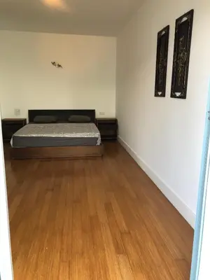 a bedroom with a bed and a wooden floor at Eden Island Apartment with a View in Sidi el Haj Bou Derbala