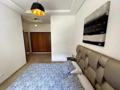 a bedroom with a bed and a painting on the wall at 5 Star Apartment Near Airport in Nouaseur