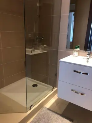 a bathroom with a glass shower with a sink at 5 Star Apartment Near Airport in Nouaseur