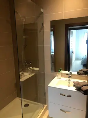 a bathroom with a shower and a sink and a mirror at 5 Star Apartment Near Airport in Nouaseur