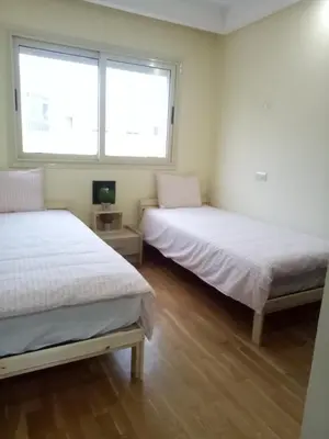 two beds in a room with two windows at Apartment with Terrace in Casablanca
