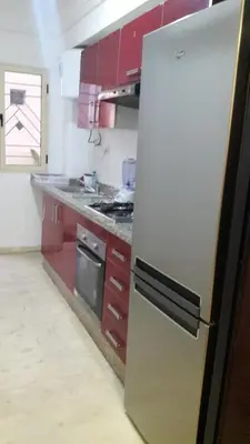 a kitchen with red cabinets and a stainless steel refrigerator at Apartment with Terrace in Casablanca