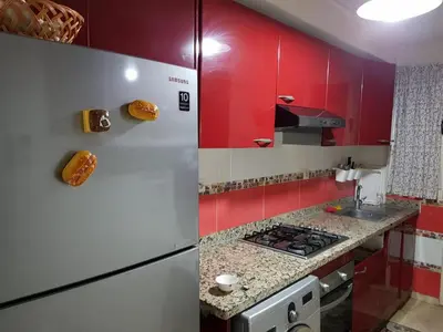 a kitchen with red cabinets and a refrigerator at Apartment with Terrace in Casablanca