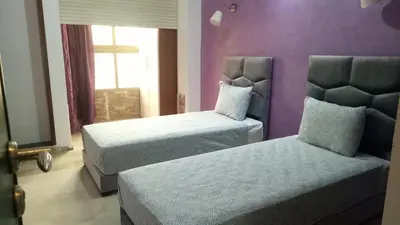 a bedroom with two beds and a purple wall at Apartment with Terrace in Casablanca