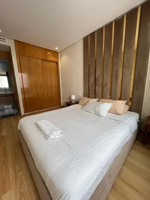 a large white bed in a room with wooden walls at Luxury appartement in Heart of Casablanca Maarif in Casablanca