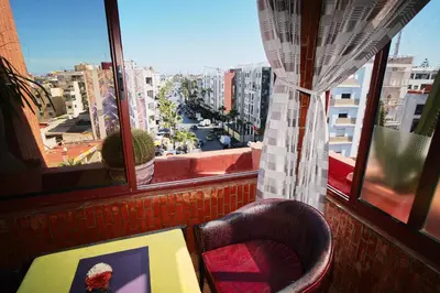 a room with a view of a city from a window at Hôtel Texuda in Rabat