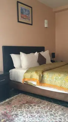 a bedroom with a large bed with white pillows at Hôtel Texuda in Rabat