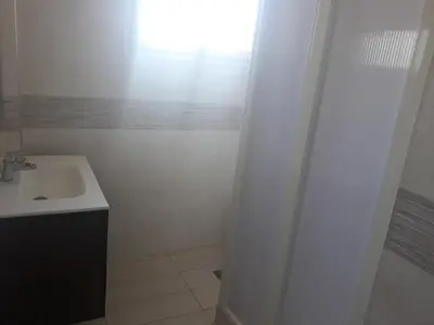 a white bathroom with a sink and a window at Maison vintage Rabat Agdal in Rabat