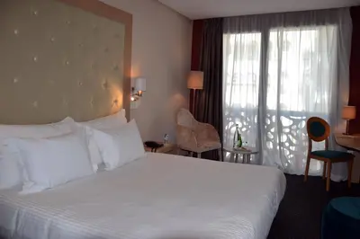 a hotel room with a large white bed and a window at Flower Town Hotel & Spa in Rabat