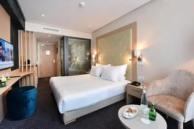 a hotel room with a bed and a chair at Flower Town Hotel & Spa in Rabat