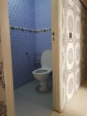 a bathroom with a toilet in a blue wall at Residence Bassatine in Temara