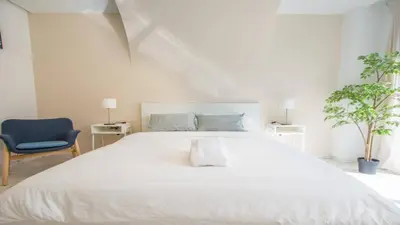 a bedroom with a white bed and a blue chair at Stayhere Rabat - Agdal 1 - Comfort Residence in Rabat