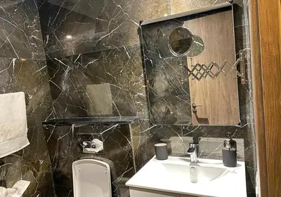 a bathroom with a sink and a toilet and a mirror at Amazing Flat in Gauthier - Breathtaking View - Best Location in Casablanca