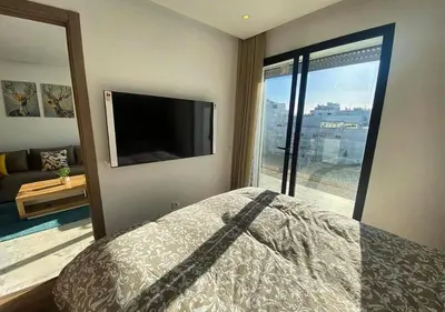 a bedroom with a bed and a flat screen tv at Amazing Flat in Gauthier - Breathtaking View - Best Location in Casablanca